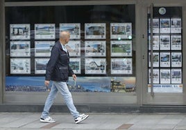 Un hombre observa la oferta de viviendas de una inmobiliaria en Gijón.