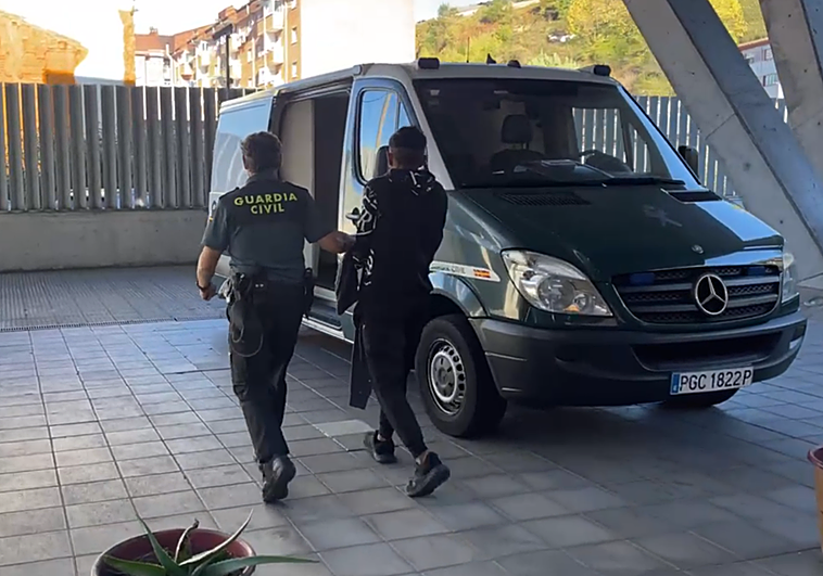 Uno de los detenidos es trasladado a un furgón en el cuartel de Sama de Langreo para llevarlo al juzgado de Pola de Siero.