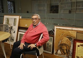 Álvaro Muñiz sentado en el despacho del Ateneo Jovellanos, junto a los cuadros de la colección de la entidad que no les dejan colgar.