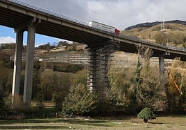 Camión circulando sobre el viaducto de Campomanes, con uno de sus vanos con andamios de 37 metros de altura.