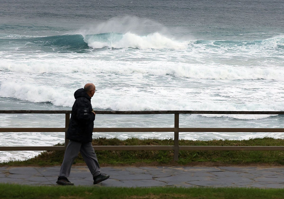Un hombre pasea junto al mar en Galicia, donde el temporal ha dejado olas de más de seis metros esta mañana.