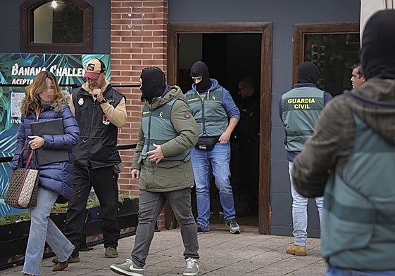 Las fuerzas de seguridad salen del local de hostelería de Montevil tras el registro.
