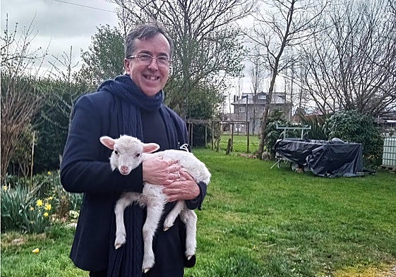 El sacerdote con un cordero en una de las aldeas donde ejerce.