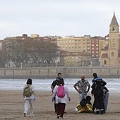 Agentes de la Policía Local y sanitarios atienden a la joven indispuesta en la playa de San Lorenzo.