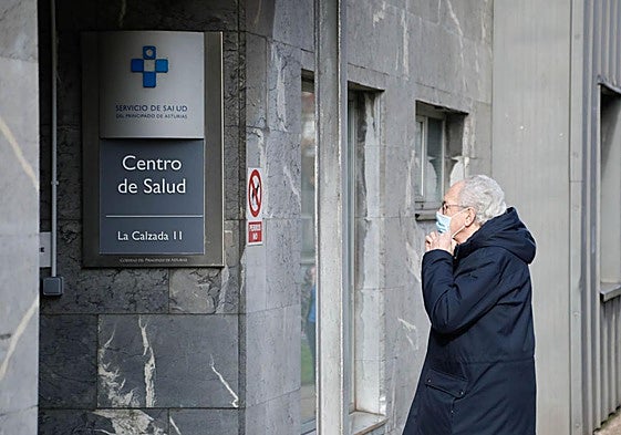 Un hombre se coloca la mascarilla para entrar en un centro de salud.