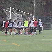 Parte de la plantilla del Real Avilés desplaza una portería portátil en un entrenamiento de esta semana en La Toba.