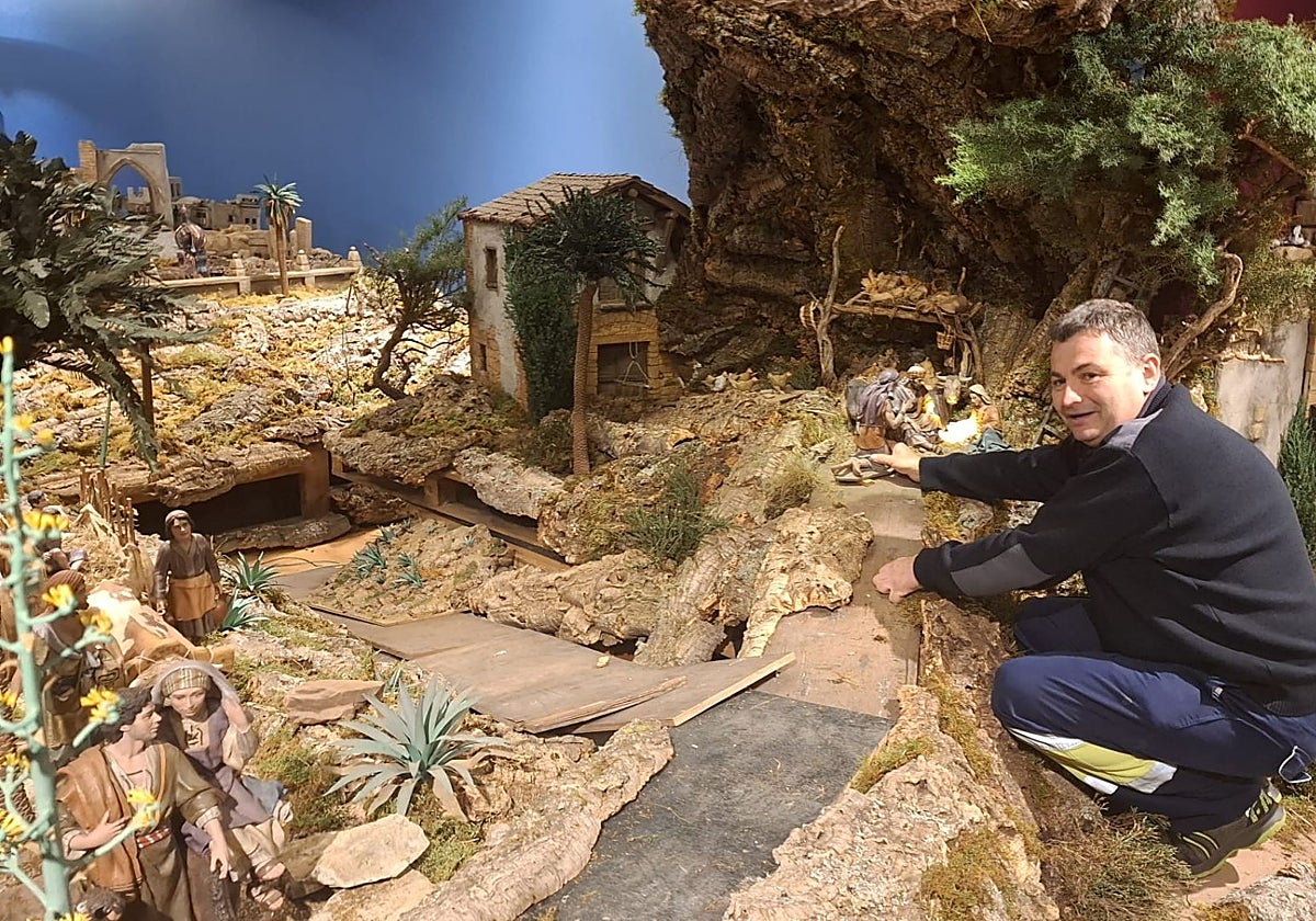 El belenista Nicolás Rodríguez coloca una de las piezas del nacimiento de La Oliva, en Villaviciosa.