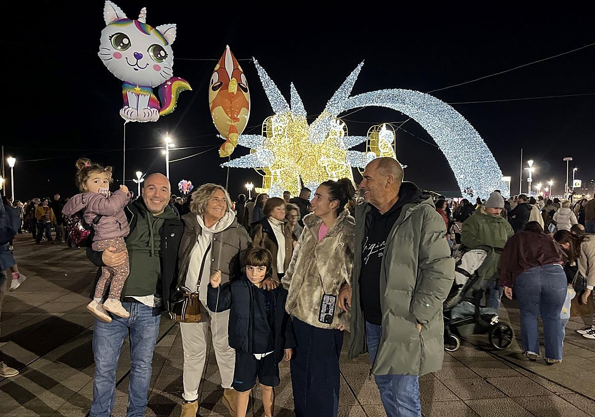 María (2 años), Jairo, la abuela Marta, Mateo (7 años), Marta y el abuelo Toño, posan delante de la 'estrellona' y los Reyes Magos, en el Náutico.