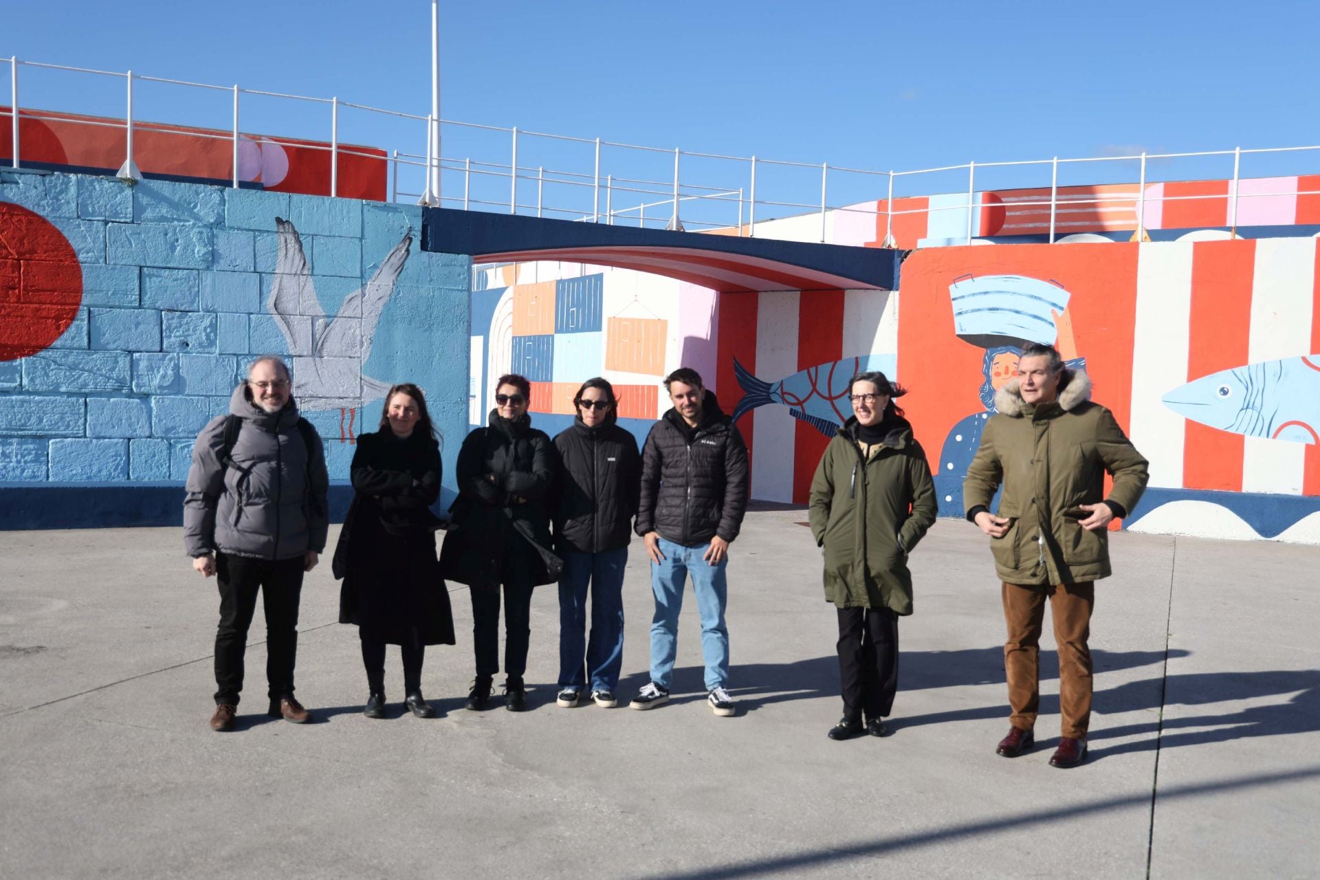 Miembros del jurado y los autores del nuevo mural que envuelve el tramo final de la punta Lequerica, con Nieves Roqueñí, presidenta del Puerto, y José Luis Barettino, director general, este martes, durante una visita al dique.