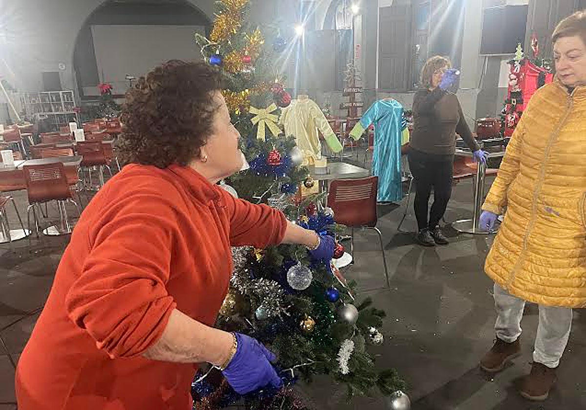 Vecinas ultimando algunos de los adornos en el Cine Ideal de Ciaño