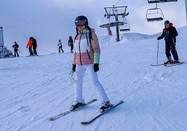 Una joven se desliza por la nieve en la estación de esquí Valgrande-Pajares.