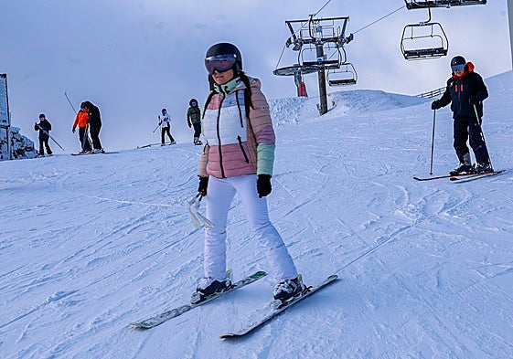 Una joven se desliza por la nieve en la estación de esquí Valgrande-Pajares.