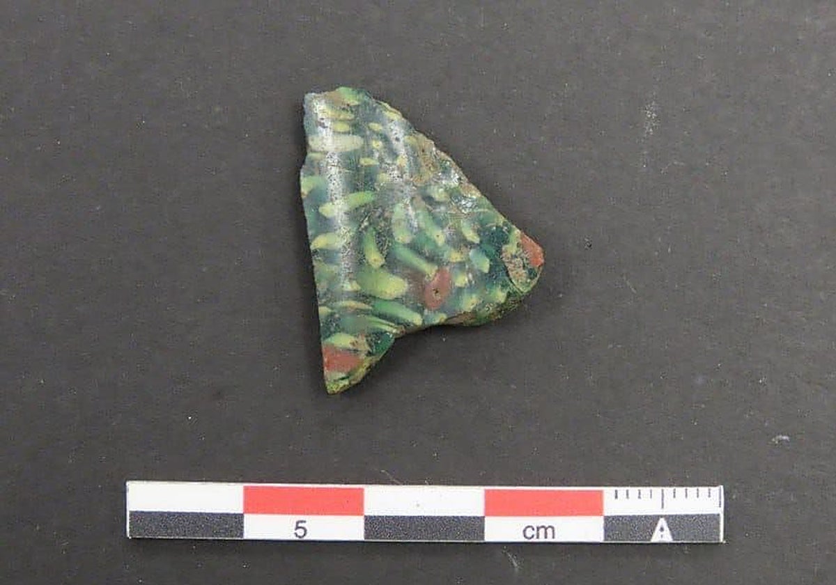 Fragmento de vidrio mosaico de tonalidad verde oscura hallado en la Campa Torres, en Gijón.