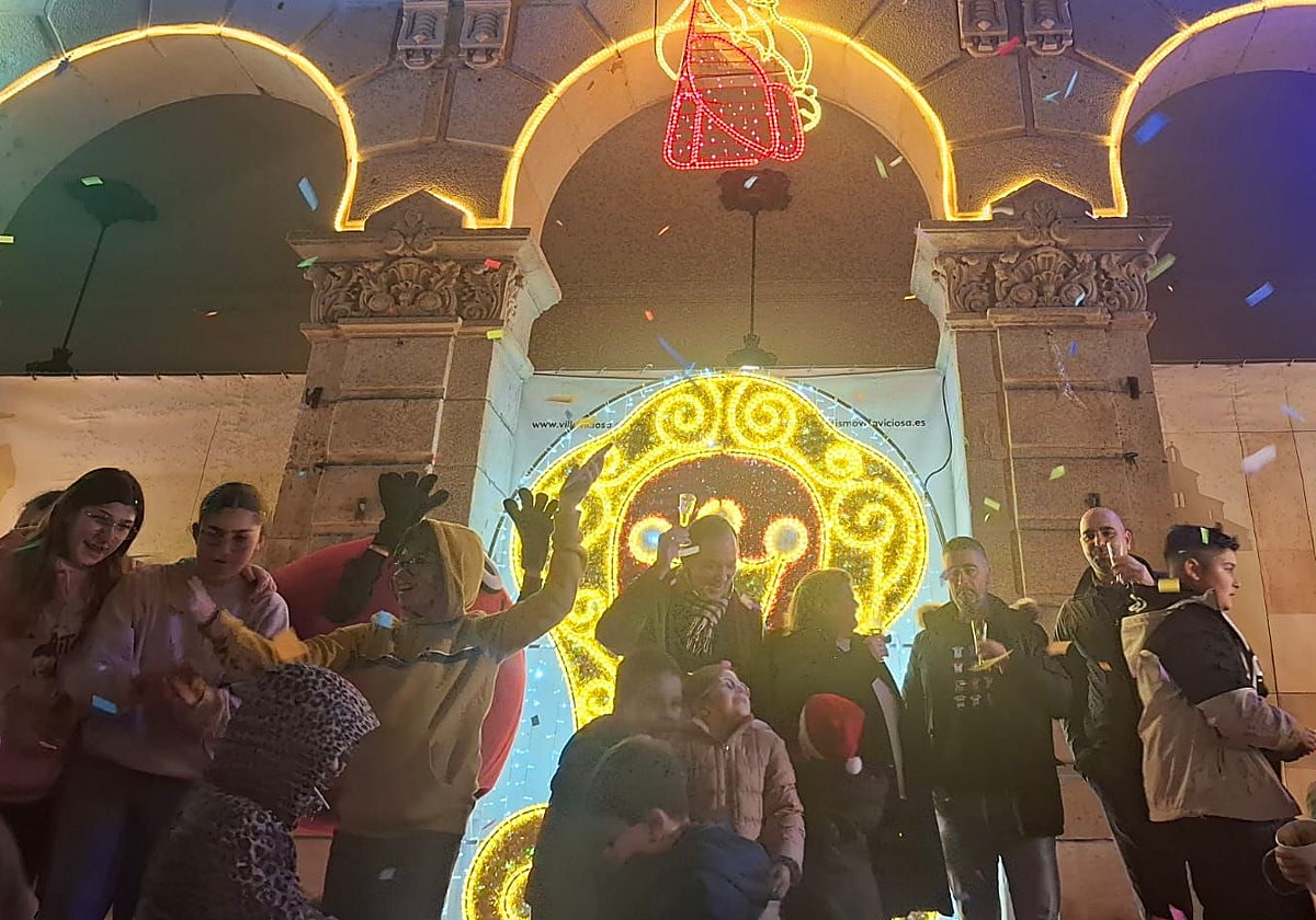 El alcalde de Villaviciosa, en el centro, brinda por la Navidad tras el encendido.