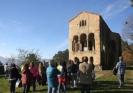 Un grupo de visitantes contempla el monumento de Santa María del Naranco.