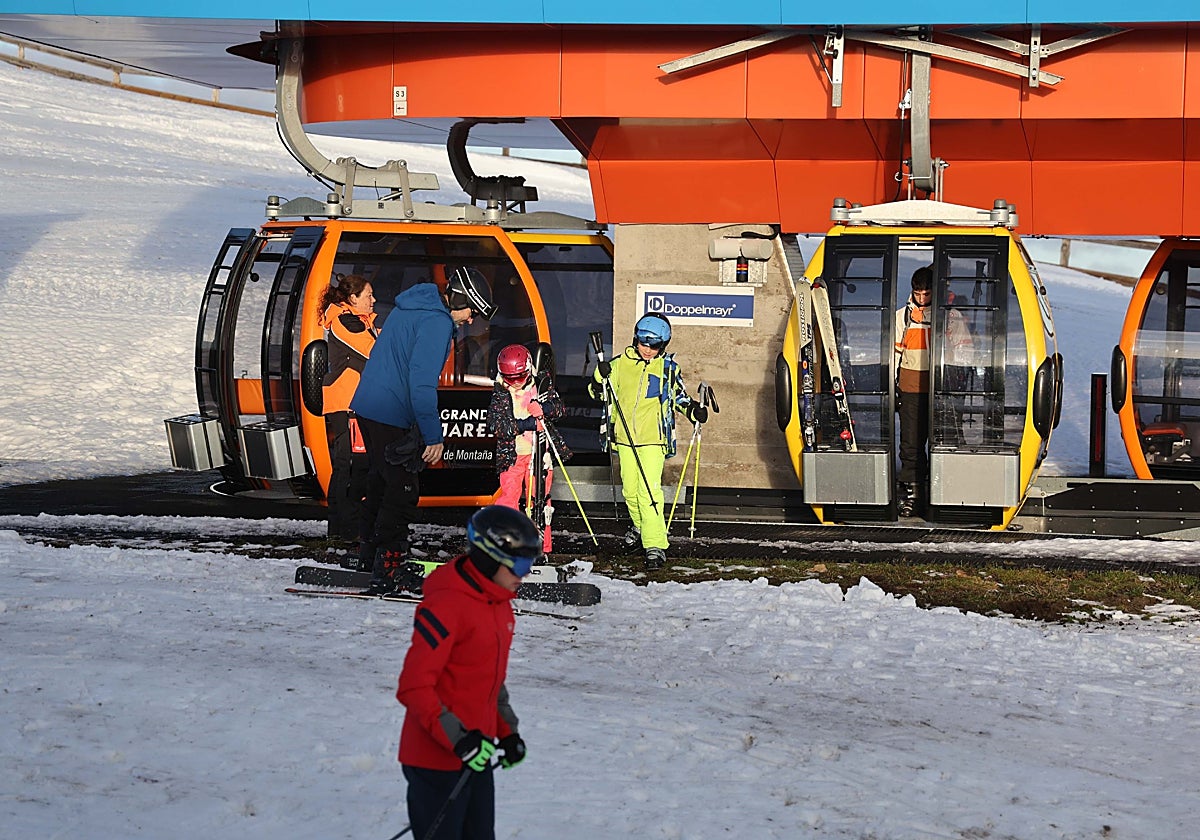Esquiadores en la zona alta de al estación bajando de la telecabina