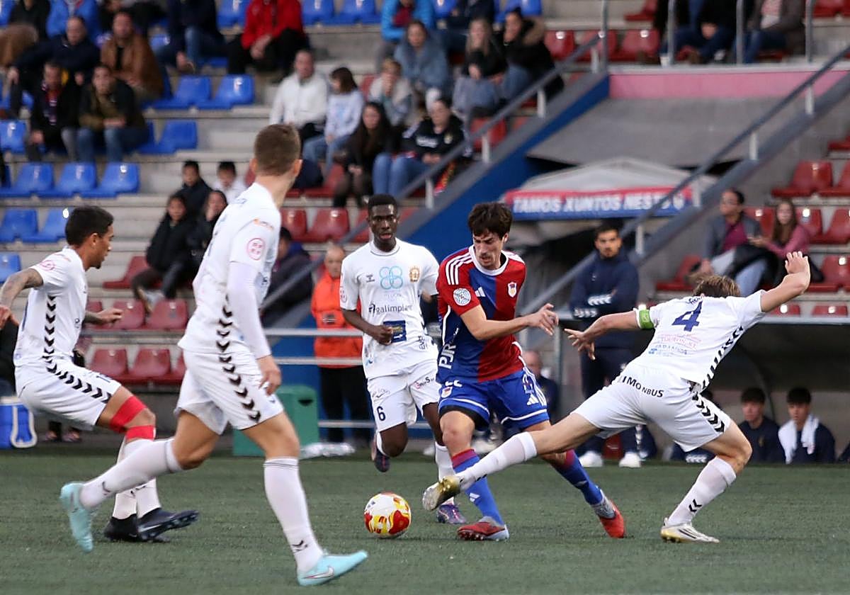 Pablo Pérez trata de deshacerse de un defensor de la Sarriana en el duelo del Ganzábal.