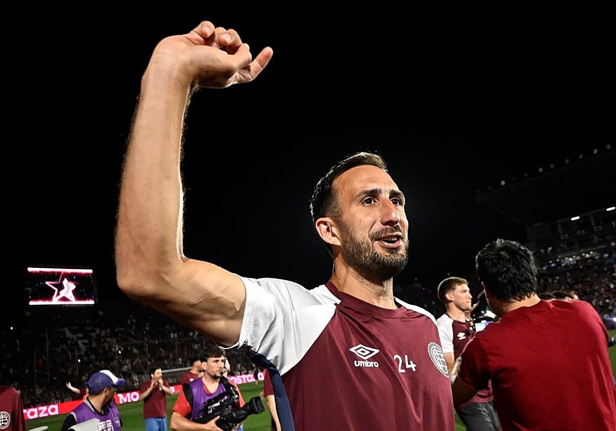 'Cali' Izquierdoz, festejando con sus compañeros de Lanús sobre el césped.