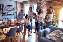 Una mujer abraza a su perro mientras charla con sus familiares.