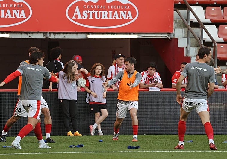 Los jugadores ya calientan sobre el terreno de juego