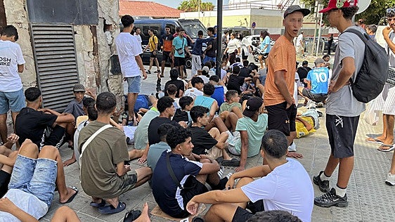 Multitud de menores migrantes esperan para su filiación frente a la Jefatura Superior de la Policía Nacional en Ceuta.