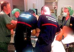 Bomberos, cirujanos y personal sanitario durante la operación para cortar el tubo en un quirófano del Ruiz de Alda. / J. E. Gómez