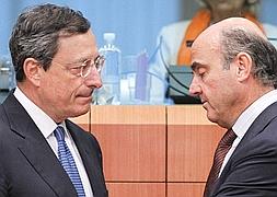 El presidente del BCE, Mario Draghi, conversa con Luis de Guindos. / Archivo