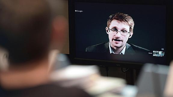 Una persona escucha a Eduard Snowden por videoconferencia.  