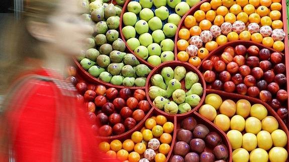 Mujer pasa por delante de un expositor con fruta española en Berlín. 