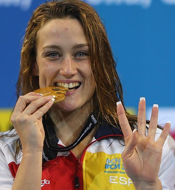 Mireia Belmonte posa con su medalla y muestra cuatro dedos. 