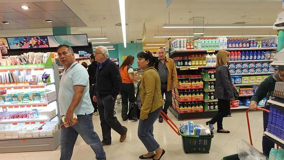 Varias personas compran en un supermercado. / 