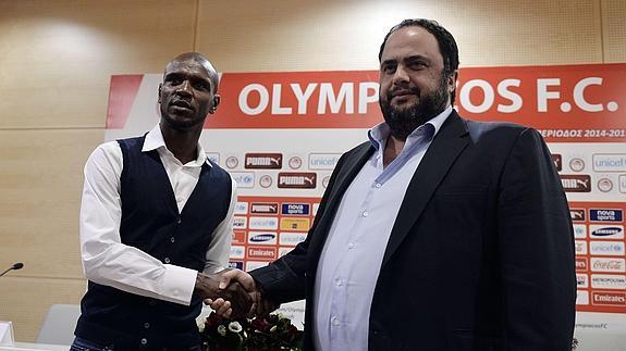 Eric Abidal (i) estrecha la mano al presidente del Olympiacos. 