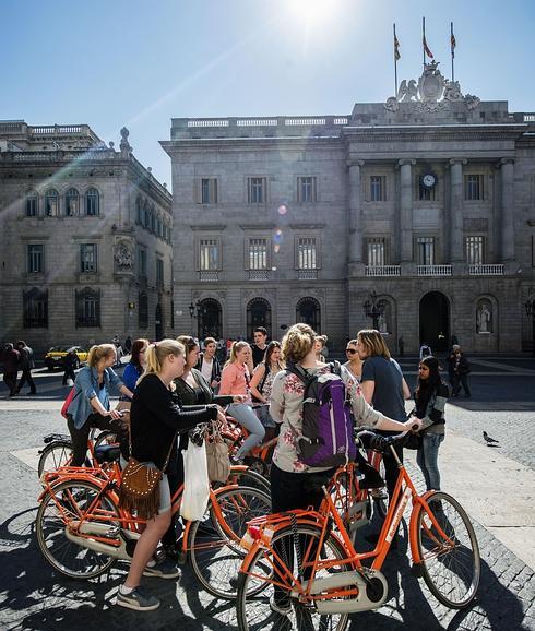 Un grupo de turistas pasea en bicicleta por Barcelona. 