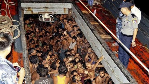 Agentes de la Policía birmana observan a un grupo de inmigrantes en una embarcación en Rakhine.