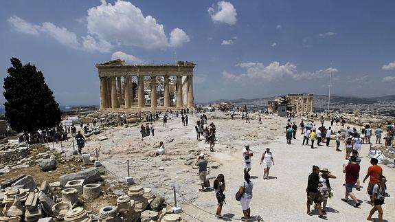 Turistas visitan la Acrópolis en Atenas (Grecia). 