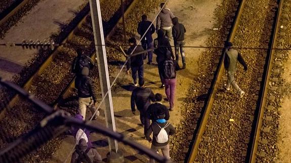 Varios inmigrantes en las vías del Eurotúnel en Calais.
