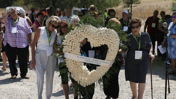 Familiares del vuelo JK5022 de Spanair portan una corona de rosas blancas. 