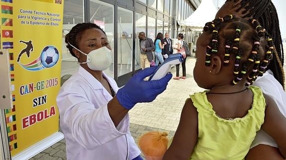 Una médico mide la temperatura de una niña.