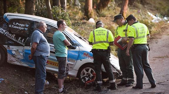 Agentes de la Guardia Civil de Tráfico inspeccionan el vehículo siniestrado.