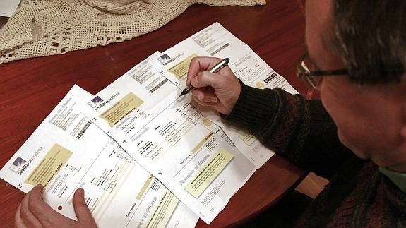 Un hombre comprueba varias facturas de la luz.