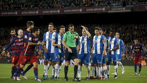 Los jugadores de Barça y Espanyol protestan al árbitro Martínez Munuera.