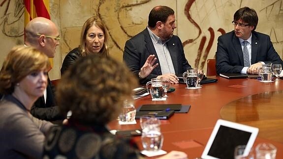 El presidente de la Generalitat, Carles Puigdemont (d), durante la reunión semanal del Ejecutivo catalán.