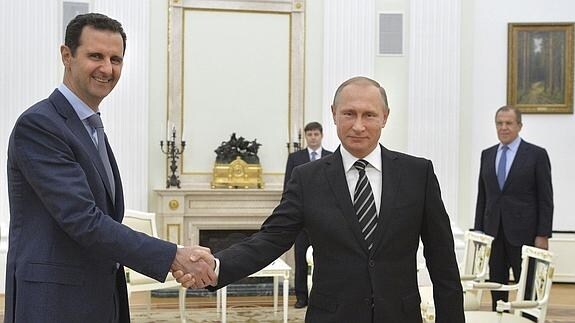 Asad (izq.) y Putin se dan la mano. 