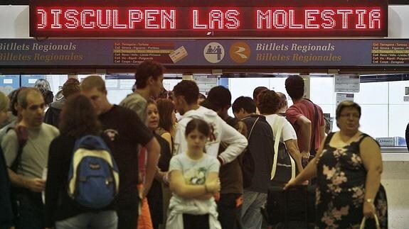 Un grupo de personas ante las taquillas de la estación de Sants en Barcelona. 