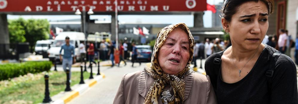 La hija de una de las víctimas es consolada por un familiar.