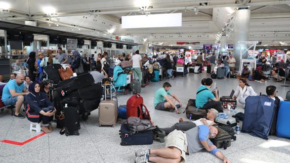 Pasajeros esperan en el aeropuerto internacional Atatürk de Estambul después de cancelarse sus vuelos por la intentona golpista. 