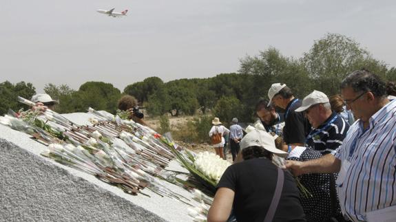 Familiares de las víctimas con flores en el lugar del accidente de 2008.