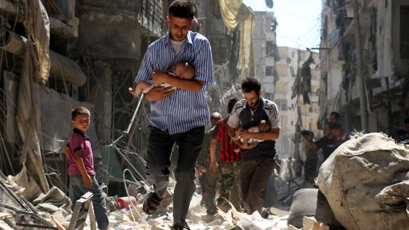 Dos padres con sus bebés tras un bombardeo en Alepo