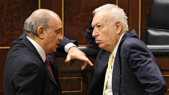 El ministro del Interior, Jorge Fernández Díaz (i), charla con el ministro de Exteriores, José Manuel García-Margallo, en el Congreso.