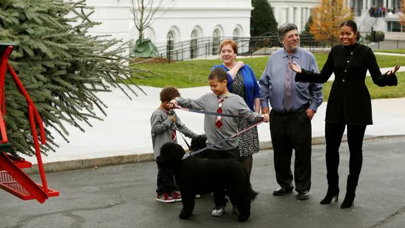 Michelle Obama recibe el árbol navideño en compañía de sus sobrinos y sus perros. 